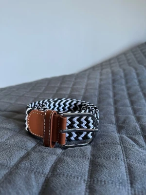 Svart vitt flätat bälte - Tja den är helt nytt längd 105cm och bred 3,5cm från BÄLTGALLERIAN