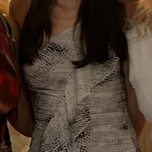 Vit och grå kortklänning med volanger - Supersnygg kort klänning från Zara med volanger och tunna axelband. Klänningen har storlek xs. Jätte ledsen att jag behöver sälja denna för den är såååå fin men tyvärr blivit för liten för mig. För bättre bilder skriv gärna 