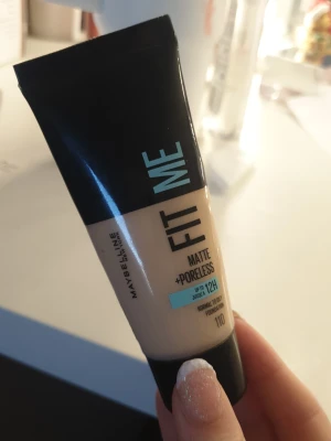 Maybelline Fit Me Matte Foundation 110 - Fit Me Matte + Poreless foundation från Maybelline i nyansen 110. Ger en matt finish och jämnar ut huden. Tuben är svart och beige med turkosa detaljer. Passar normal till oljig hud och håller upp till 12 timmar. Den är använd men det finns ganska mycket kvar