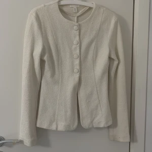 Vit kavaj med struktur och knappar - Säljer denna vita tröja , sitter tajtare vid midjan och ger form!