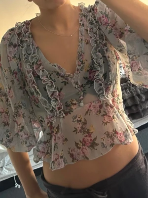 Blommig topp - Blommig topp med detaljer fram, trekvartsärmad 