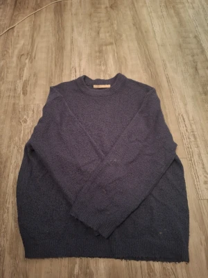 Mörkblå stickad tröja - Mysig mörkblå stickad tröja med rund hals och långa ärmar från lager 157. Andvänt flera gånger och därför i andvänt skick. Inga  fläckar samt hål. Storlek S med loose fit. Köptes för 150kr, priset kan förhandlas!