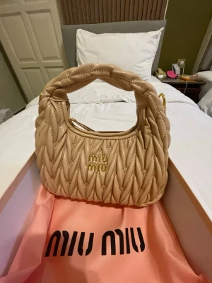 Miu Miu väska - Snygg Miu Miu väska. Kan inte skicka nu kan skicka tidigast den 14 januari. Box och tote bag ingår och ett band. Har en innerficka.