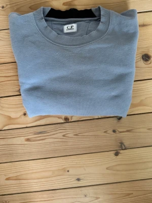 C.P. Company tröja  - Säljer en snygg ljusblå tröja från C.P. Company. Den är i väldigt bra skick. Säljer den för att den har blivit för liten, jag är 188 och väger 77kg.