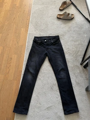 Svarta jeans från Nudie Jeans, 28/30 - Säljer ett par svarta jeans från Nudie Jeans i storlek 28/30. Jeansen har klassisk femficksdesign, raka ben och diskreta svarta sömmar på bakfickorna. Materialet är jeans och färgen är mörk, vilket ger en clean och stilren look. Nypriset på byxorna är runt 1500kr. Jag säljer dessa pågrund av att dom blivit försmå, tveka inte på att höra av er om ni undrar något🤩🙌🏼