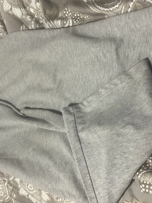 Grå mjukisbyxor med loose passform - Säljer ett par grå mjukisbyxor med skön loose passform. Byxorna har en enkel design utan synliga detaljer och är tillverkade i mjukt bomullsmaterial. Perfekta för chill dagar eller när du vill vara extra bekväm.