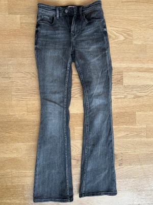 Bootcut jeans från Vero Moda - Snygga mörkgrå bootcut jeans från Vero Moda. Jeansen har en lätt tvättad look och är tillverkade i mjukt denim-material. 💕Strl S/L32