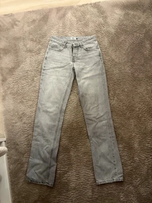 Ljusgrå raka jeans från lager 157 - Säljer ett par ljusgrå jeans från 157 med klassisk femficksmodell och raka ben. Jeansen har normal passform och är tillverkade i ett mjukt jeanstyg som är perfekt för en avslappnad look. Passar dig som gillar stilrena och enkla basplagg.