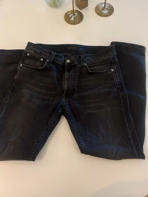 Nudie jeans  - Säljer ett par svarta nudie jeans i bra skick. Jensen har en bra passform och är i en riktigt snygg färg.