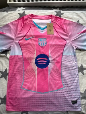 FC Barcelona Rosa Matchtröja 2025 – Ny - Barcelona matchtröja i rosa från säsongen 2025. Alternativt ställ som används under året.  – Helt ny – Matchtröja 2025 – Stilren design – Inte lika vanlig som hemmastället  Skickas direkt.