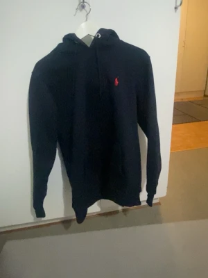  Mörkblå Ralph Lauren hoodie  -  Mörkblå Ralph, Lauren, hoodie med snören och en Rolf Lauren detalj