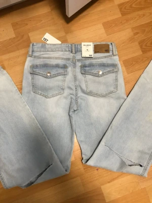 Bootcut ljusblå jeans från 157 - Bootcut jeans i ljusblå tvätt från 157 med klassiska fickor bak och snygga detaljer som slits vid benslutet. Original pris 400kr. Mitt pris 175kr