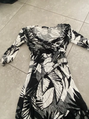 Svartvit mönstrad klänning Ilse Jacobsen - Säljer en svartvit klänning från Ilse Jacobsen med coolt grafiskt mönster. Klänningen har lång ärm, v-ringad hals och är i mjukt, stretchigt material. Perfekt för dig som gillar statement-plagg med unik design.