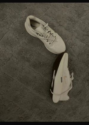 Nike vita sneakers med brun sula - Nike sneakers i vitt med brun sula och mesh-överdel. Skorna har snörning och en rund tå, samt en platt sula med tydligt mönster för extra grepp. Perfekta för dig som gillar stilrena och sportiga skor med snygga detaljer. Ny pris 1600