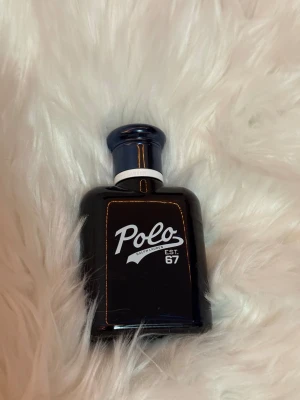 Ralph Lauren Polo 67 parfym  - Stilren parfym från Polo Ralph Lauren, EST. 67. Perfekt för dig som gillar klassiska och sportiga vibbar. Snygg mörkblå flaska som sticker ut i samlingen. 