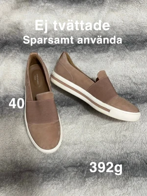  slip-on sneakers från clarks - Snygga slip-on sneakers från clarks i en gammelbrun/gammelrosa nyans med bred resår över vristen. Skorna har vit platt sula. Perfekta för en avslappnad och trendig look.🌸 Sparsamt använd. Ej tvättad. Storlek 40. Svårt att beskriva färgen men typ gammelrosa/brunrosa