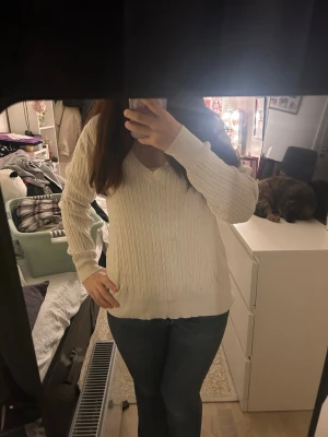Vit kabelstickad tröja H&M V-ringad - Kabelstickad vit tröja från H&M med snygg v-ringning och ribbade muddar. Långärmad modell i mjuk bomullsblandning som är perfekt för lager på lager. Klassisk och enkel design som funkar till allt.