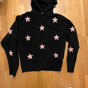 Sandro Paris Hoodie - Riktig snygg och unik hoodie från Sandro Paris. Den är så gott som ny och är knappt använd. Den har cool design med stjärnor som sticker ut. Stjärnorna är i ett annat material som man kan se ifall man zoomar in lite. Hör av er ifall ni har några funderingar. 