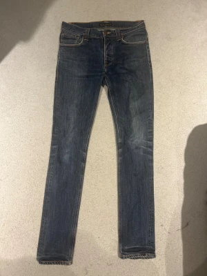  Nudie Jeans, 32/36 - Snygga blå jeans från Nudie Jeans med modellen Grim Trim. Liten bli fläck på högra bak byxfickan. Storlek 32,36