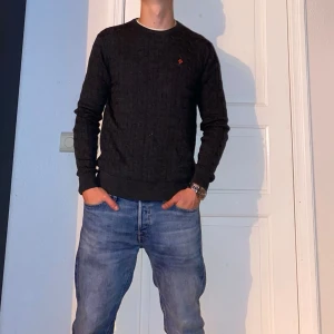 Mörkgrå kabelstickad tröja från Morris - Mörkgrå kabelstickad tröja från Morris i storlek L. Finns däremot ett litet hål på framsidan av tröjan. Syns knappt vid användning. Väldigt lätt att fixa. Nypris: 1995kr. Mitt pris: 449kr. Vid frågor eller funderingar, tveka inte att höra av dig.