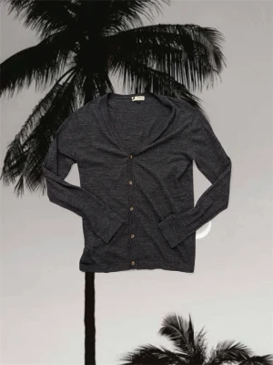 Cardigan  - Snygg mörkgrå kofta från linen blend  i mjuk och tunn ullmix. Koftan har v-ringad hals, långa ärmar och fem knappar framtill. Perfekt att slänga över en t-shirt eller linne för en chill och stilren look.