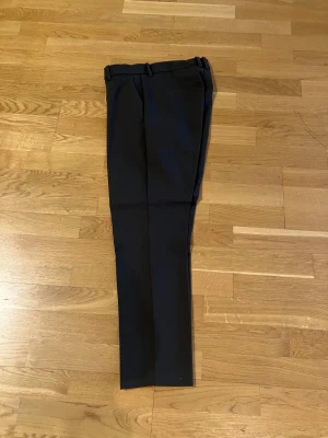 Militärgröna kostymbyxor/slacks med raka ben - Snygga militärgröna kostymbyxor/slacks med klassisk rak passform och bälteshällor. Perfekta för en clean och stilren look. Tillverkade i ett mjukt material som känns bekvämt hela dagen.