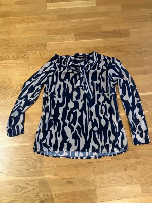 Knytblus i marint och beige mönster - Jöttefin knytblus med tunt foder som gör den skön att bära. Fint tungt fall