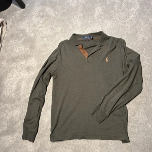 pikétröja Polo Ralph Lauren - Storlek L SLIM FIT. Snygg grön långärmad pikétröja från Polo Ralph Lauren med klassisk krage och knappar framtill.  