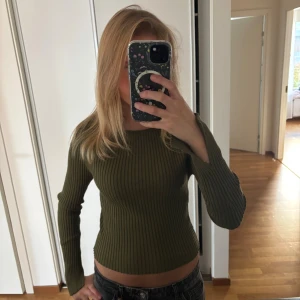 Olivgrön ribbad långärmad topp - Säljer en olivgrön ribbad topp med lång ärm och tight passform. Inga defekter och nästan aldrig använd