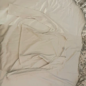 Ribbad vit långärmad topp - Säljer en stilren vit långärmad topp med diskret ribbad struktur. Toppen har en klassisk rund hals och är figurnära runt midjan. Säljer pga att den inte kommer till användning. Pris kan diskuteras 💞