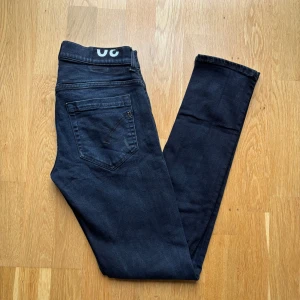 Svarta dondup George  - Säljer ett par svarta skinny fit jeans från dondup. Jeansen har klassisk femficksdesign, smal passform och är tillverkade i en stretchig bomullsblandning med polyester. Perfekta för dig som gillar en tajt look och vill ha bekväma jeans till vardags. W30, kom gärna med frågor/offer✌️