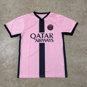 PSG rosa fotbollströja Qatar Airways - Snygg rosa PSG fotbollströja med svart vertikal rand och svarta detaljer vid krage och ärmslut. Tryck med Qatar Airways på bröstet och PSG-logga. Tillverkad i lätt och ventilerande material, perfekt för träning eller match.