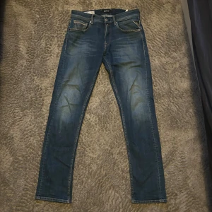 Replay jeans - Snygga Replay Grover jeans i klassisk blå denim med lätt slitning. Jeansen är i storlek w31/l32 och har en rak passform. Hör av er om ni har minsta lilla fråga!