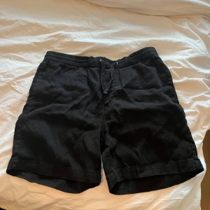 Svarta shorts från Zara - Svarta shorts från Zara i storlek M. De har elastisk midja med snörning och två fickor framtill. Materialet är bomull och linen, avslappnad passform. Perfekta för varma dagar och enkel stil. M/S