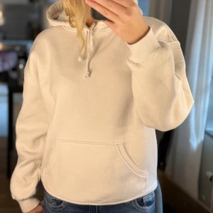 Vit hoodie från BikBok med huva - Säljer en vit hoodie från BikBok i storlek XS. Tröjan har huva med snörning, magficka och långa ärmar. Mjuk insida och klassisk passform, perfekt för chill dagar. Enkel och stilren design som funkar till det mesta.
