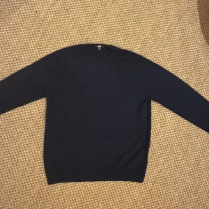 Mörkblå kashmirtröja från Uniqlo - Säljer en stilren mörkblå rundhalsad tröja från Uniqlo i 100% kashmir. Tröjan har lång ärm och klassisk passform, perfekt för dig som gillar en clean och lyxig look. Supermjuk och skön mot huden. Tröjan är storlek XL i junior storlekar men passar dig som har S.