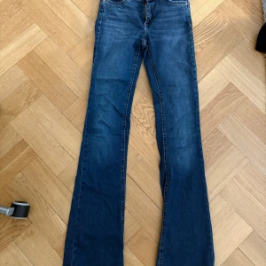 Blå bootcut jeans från ONLY - Snygga blå jeans från ONLY med klassisk femficksdesign och bootcut-ben. Jeansen har normal midja och är gjorda i mjukt denimtyg med lätt stretch. Perfekta för dig som gillar en tidlös look med lite utsvängda ben.