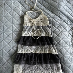 Söt sommarklänning - Supersöt klänning med virkade axelband och överdel i vitt, samt lager av svart och vit spets.