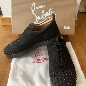 Christian Louboutin svarta skor med nitar - Säljer ett par snygga svarta Louboutin skor. De har ett litet mindre hål på baksidan av skon som ni ser på bilden, men man märker inte när man använder de. Box och dustbag medföljer. Pris kan diskuteras vid snabb affär. Hör av för frågor eller funderingar. 