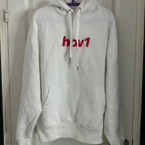 Vit Hov1 hoodie med röd logga - Säljer min hov1 tröja som jag köpte på deras hemsida. Man kan inte få tag på tröjan längre. Använd 1 gång på en konsert och är i som nytt skick! Liten liten skavank som knappt syns då min vän kom åt med autograf pennan. Går säkert bort med vanish. Nytvättad och stryks innan paketet skickas. Skickas ofta samma dag eller morgonen efter 🩷PRIS KAN DISKUTERAS 