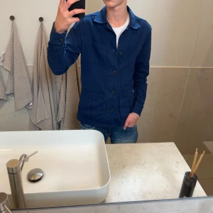 John Henric overshitt - Snygg marinblå overshirt från John Henric i storlek xs. Killen på bilden är 174 och den är i toppskick. Hör av er vid frågor och priset är inte hugget i sten!