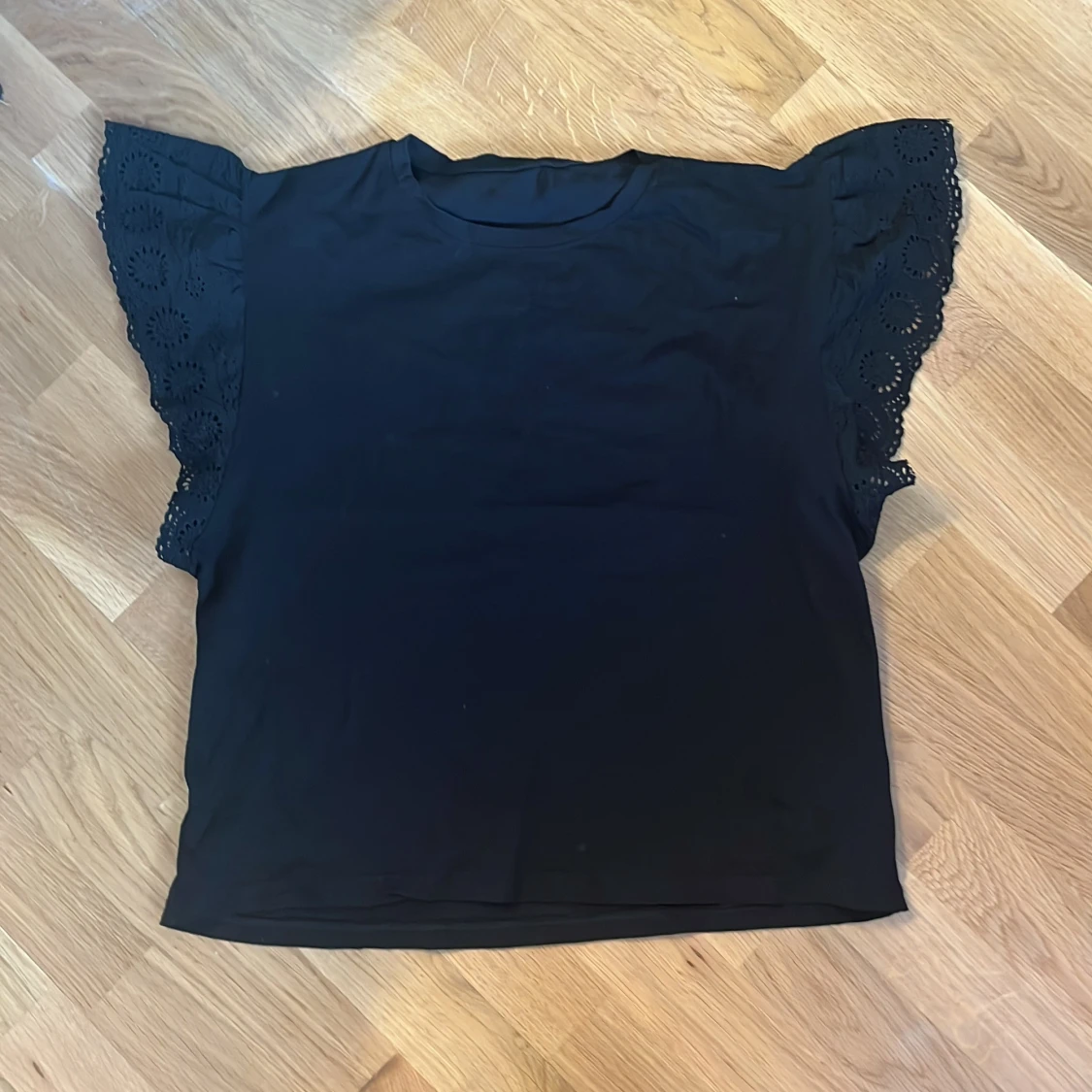 Svart blus med broderade volangärmar