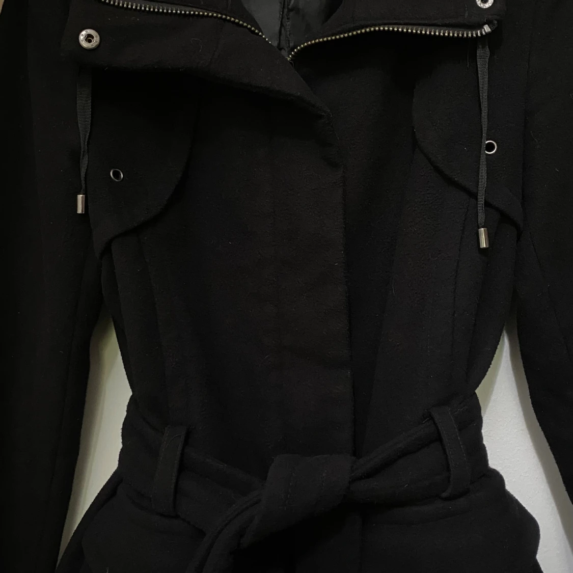 Svart kappa med bälte och dragkedja