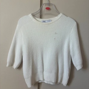 Vit stickad tröja från Zara - Mysig vit stickad tröja från Zara med halvlånga ärmar. Tröjan har två små hål men det märks knappt.💕