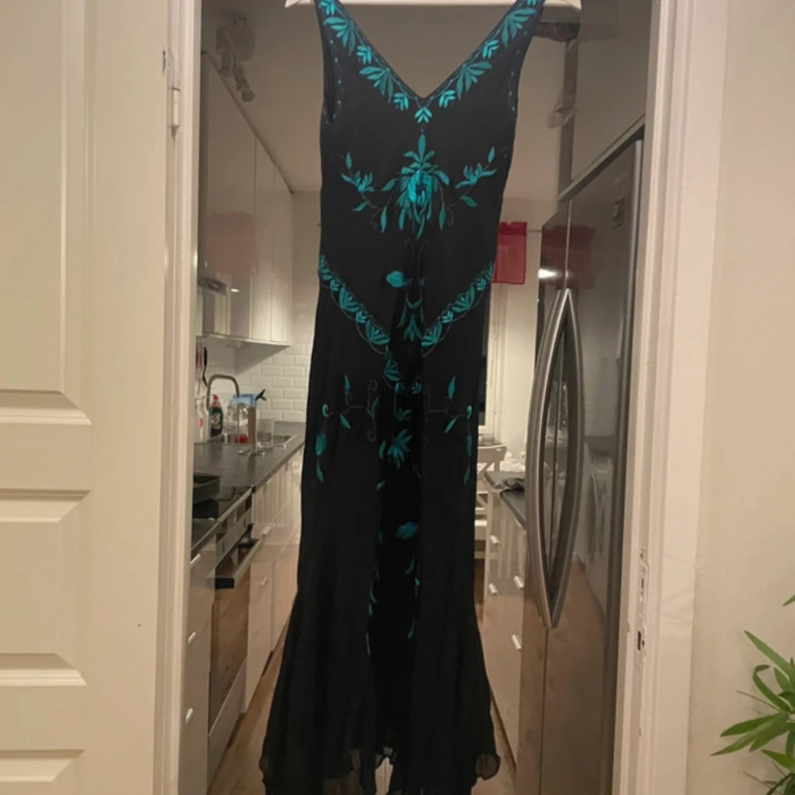 Svart långklänning med turkos broderi