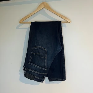 Replay Anbass jeans - Replay Anbass jeans i storlek W32/L32. Mörkblå denim med slim fit-passform och stretch som gör dem bekväma. Bra skick utan hål eller fläckar. Nypris runt 1500–2000 kr.  Mått: A (midja): 39 cm B (lårvidd): 26 cm C (fotvidd): 16 cm D (innerbenslängd): 68 cm  Säljes för 400 kr. 