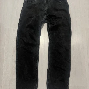 Levi's svarta jeans  - Svarta Levi's 555 jeans med klassisk femficksdesign och raka ben. Jeansen har en snygg mörk tvätt och är tillverkade i slitstarkt denim. Perfekta för dig som gillar en tidlös och clean look. Nypris 1200kr