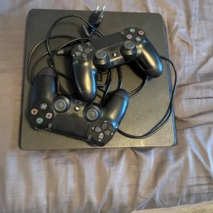 PlayStation 4 med 2 handkontroller och 8 spel - Säljer en PlayStation 4 i fint skick med två original DualShock 4-kontroller och åtta populära spel bla FIFA, GTA V, Avengers och Star Wars Battlefront. Allt fungerar som det ska skador på kontrollerna men de fungerar och har ingen stick drift eller problem annars endast ytliga skador. 