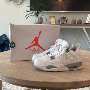 Nike Air Jordan 4 oreo - Nike Air Jordan 4 oreo med vit ovandel i skinn, grå detaljer och stänkmönstrad mellansula. Klassisk Jumpman-logga i rött på plösen och i grått på hälen. Skorna har meshpaneler, snörning och en chunky siluett som ger en ikonisk streetwear-look. Ny pris ungefär 5500kr mitt pris 799kr😉