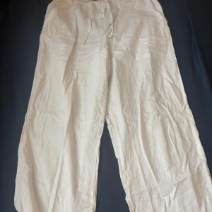 Vita linnebyxor från Gina Tricot - Snygga och luftiga vita linnebyxor från Gina Tricot med resår och snörning i midjan 